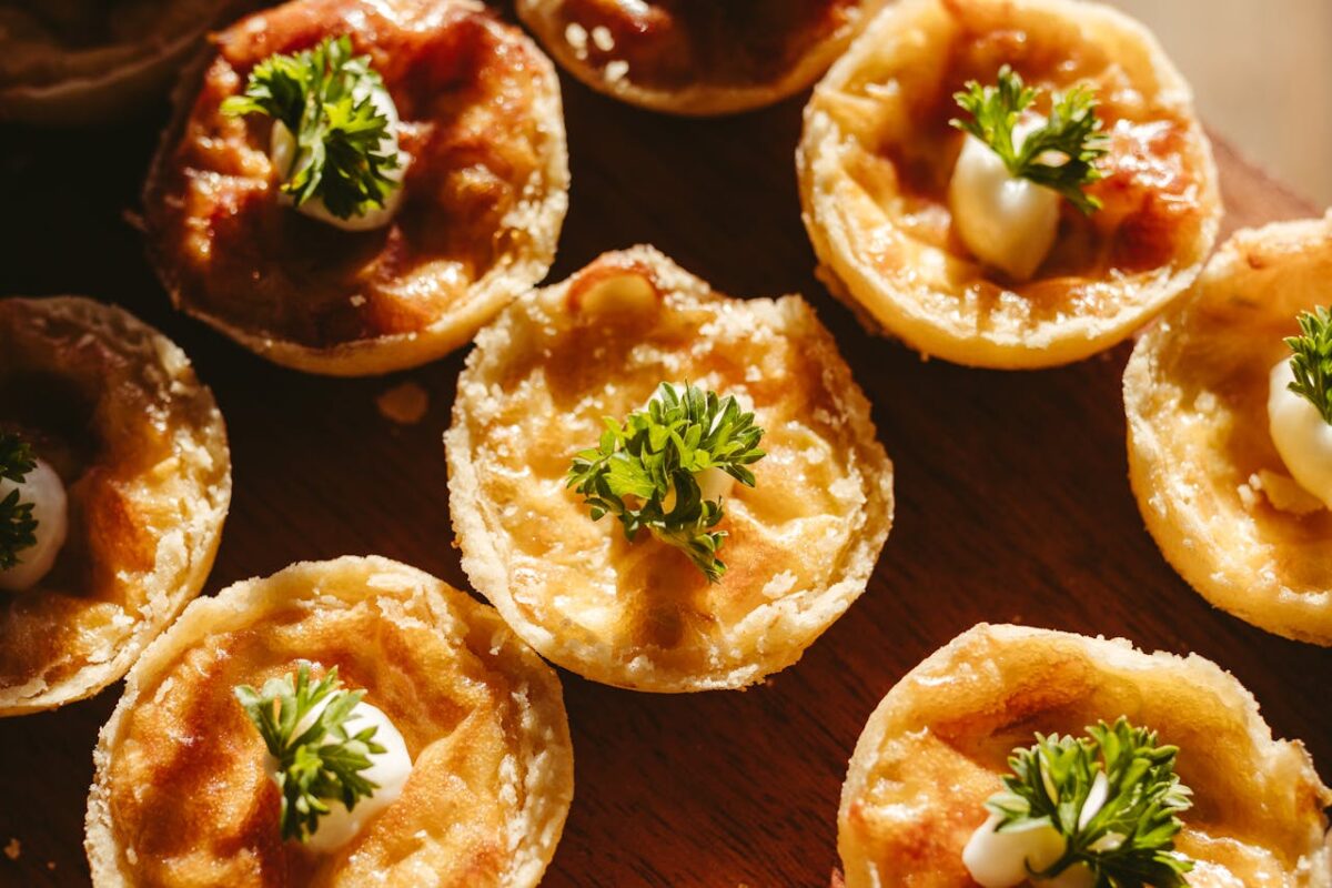 Delicious cheese tarts garnished with fresh parsley on a rustic wooden table, perfect for appetizers.