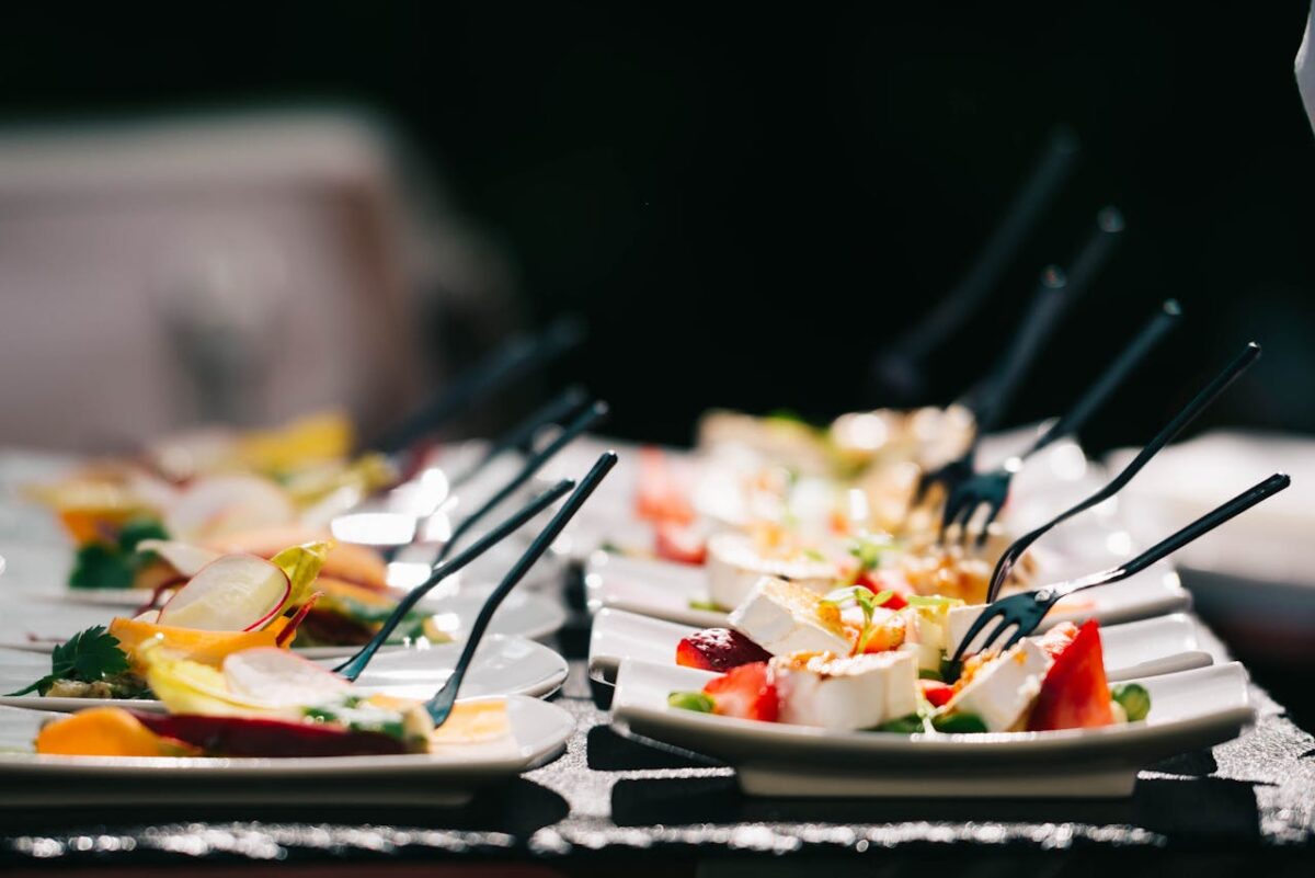 Stylishly arranged cheese and fruit appetizers on plates, ideal for events.